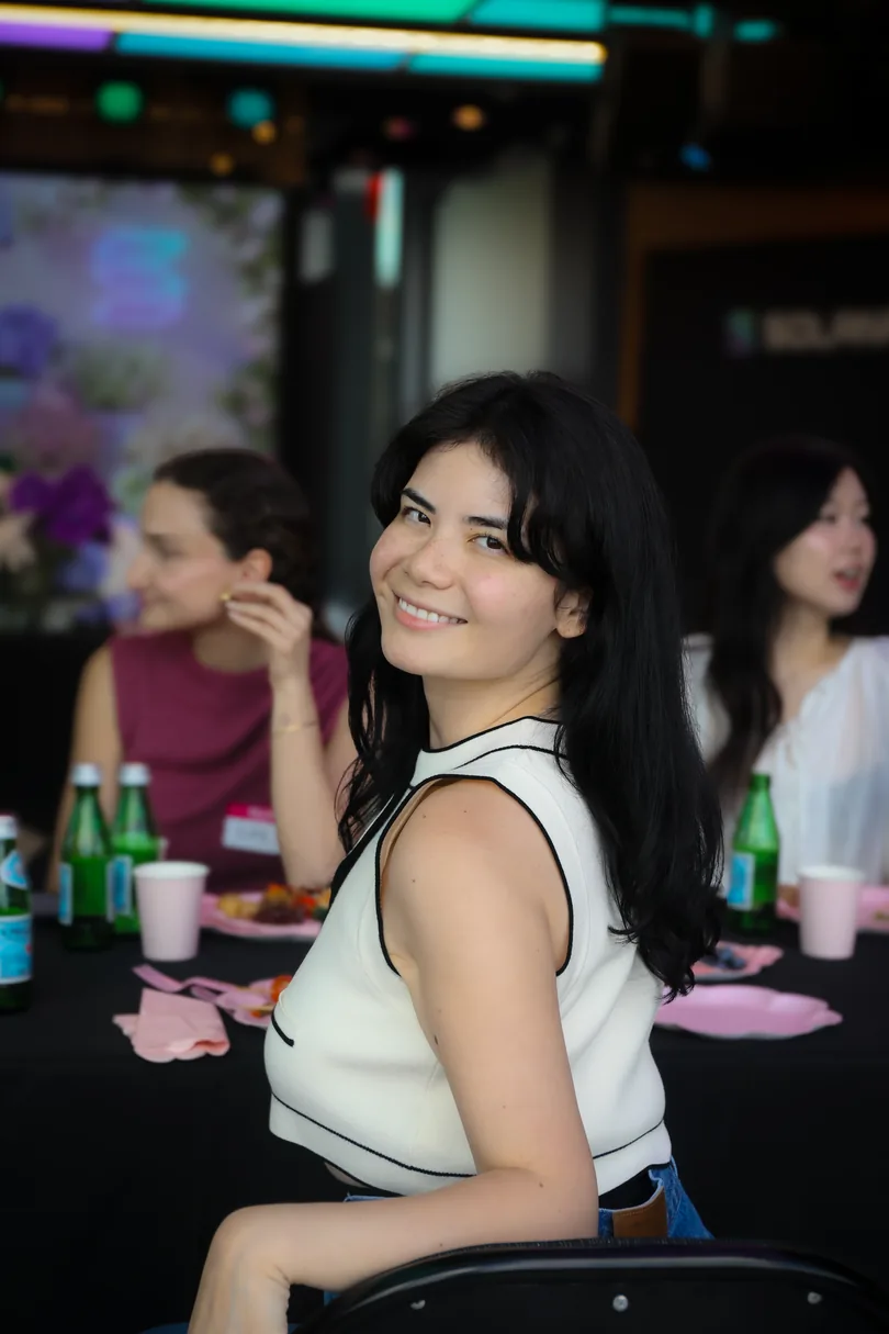 Florence Vuong, co-founder of Babes Net, turning to smile at the camera at a Babes Net table