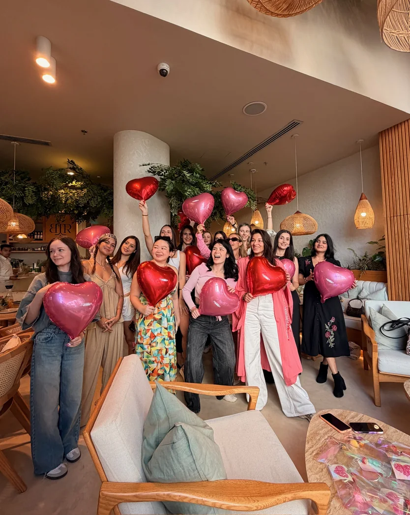 Babes Net members together at an event, holding heart balloons