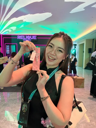 Shanny holding up her pink Babes Net key, conference lanyard around her neck